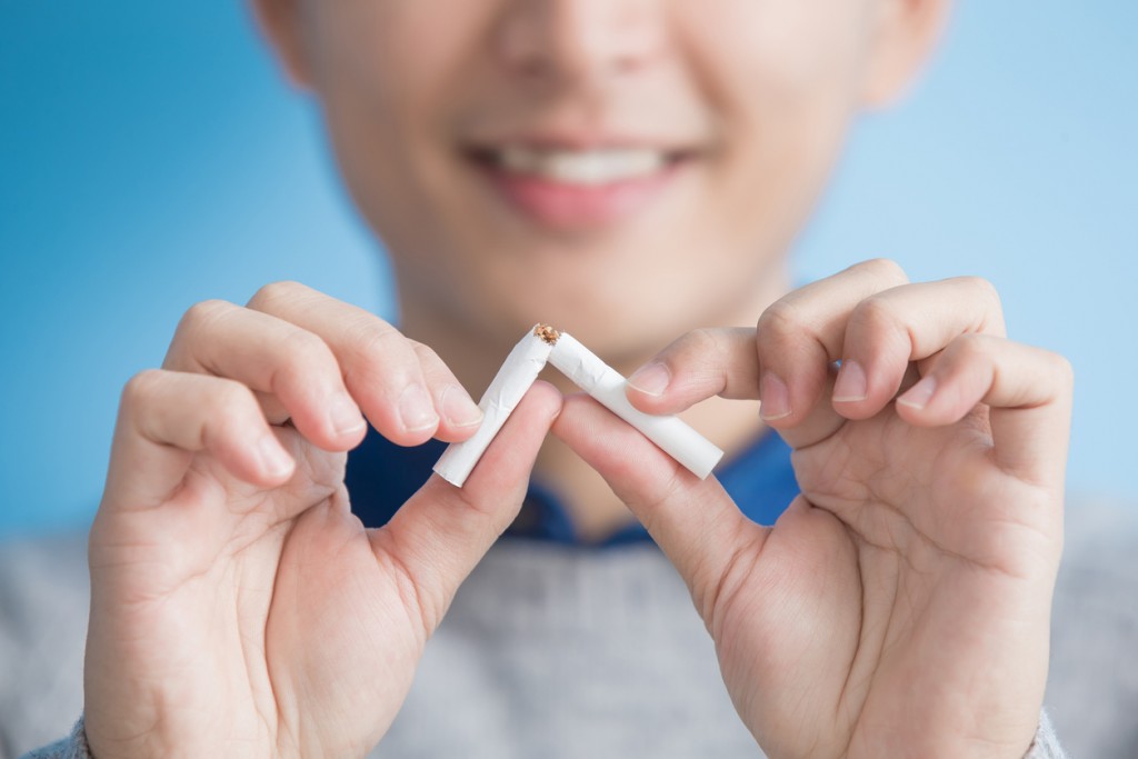 man quit smoking with blue background, asian