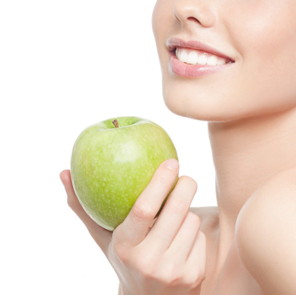 beauty portrait of attractive young caucasian smiling woman  isolated on white studio shot healthy eating green apple toothy smile happy cheerful makeup teeth head and shoulders vitamin fruits diet