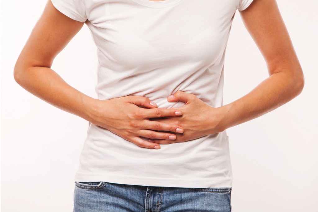 Woman heaving belly ache, on white background