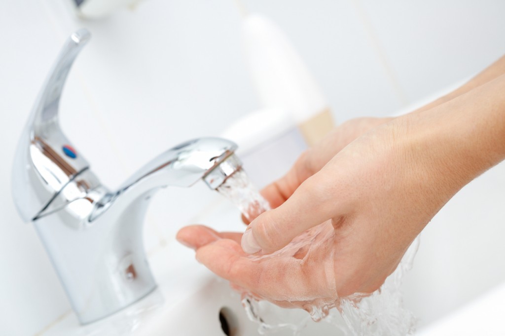 Close-up of human hands being washed under pure water from tap