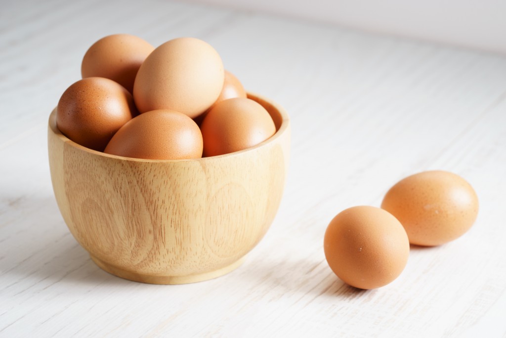 brown chicken eggs in wooden bowl
