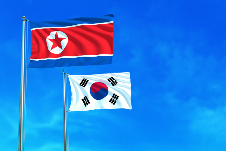 North and South Korea flags on the blue sky.