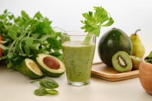 healthy green smoothie with banana, spinach, avocado and chia seeds in a glass cup on a light background. Healthy eating diet weight loss. Drinking green healthy smoothie concept.
