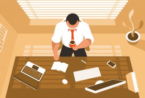 Businessman sitting at the desk with a laptop and desktop PC and drinking the coffee