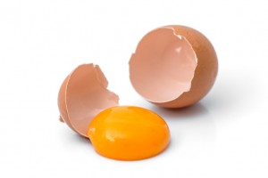 egg yolk in egg shell, cracked egg white isolated on white background