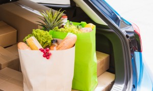 Grocery service giving fresh vegetables in wooden basket on back car