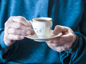 Elderly hands holding a cup of coffee