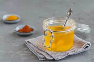 Healthy homemade Ghee or clarified butter in a jar, turmeric and paprika powder on grey concrete background. Healthy Ayurveda food concept.