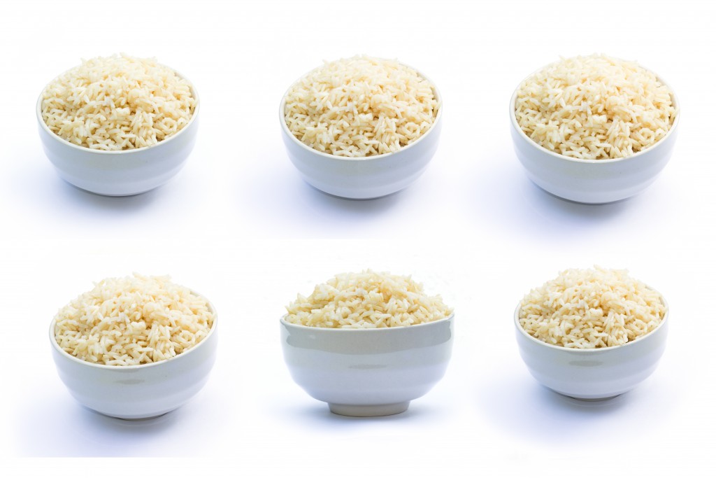 Brown rice in white bowl on a white background