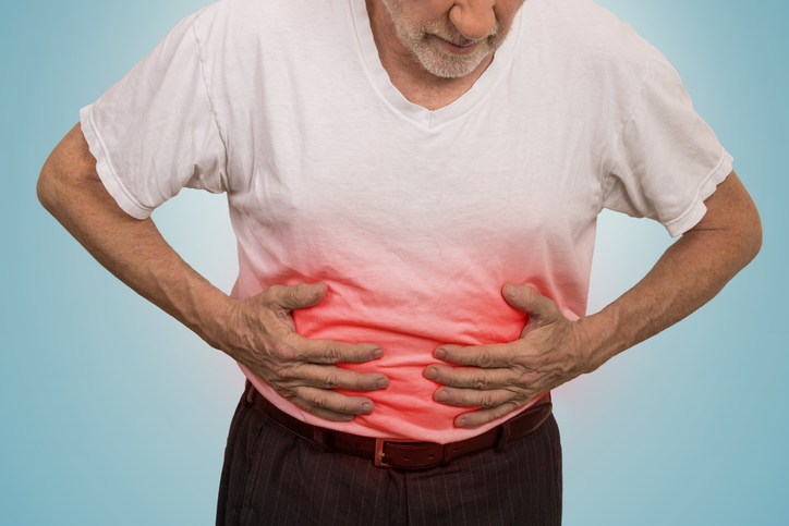 Stomach ache, man placing hands on the abdomen isolated on light blue background