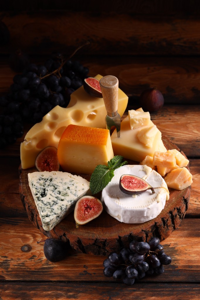 assortment of cheese, camembert and parmesan on wooden background