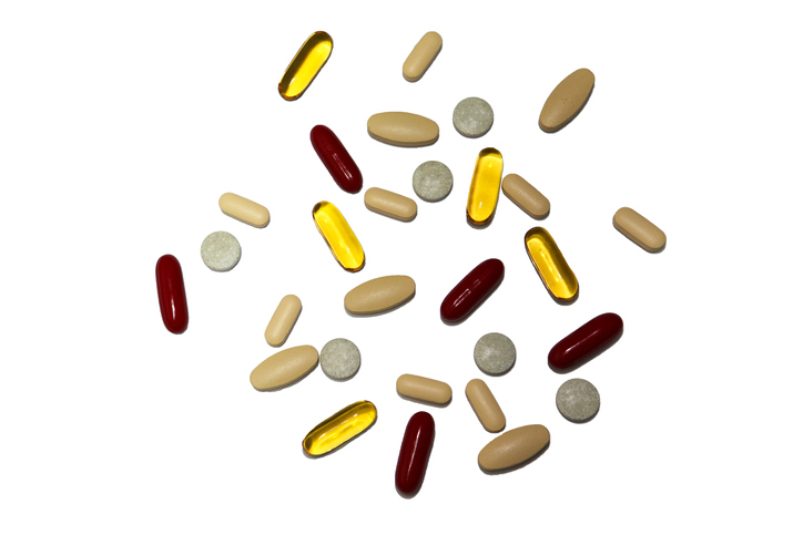 Vitamin supplement on white background including vitamin C, Vitamin E, vitamin B, Fish oil, Calcium.