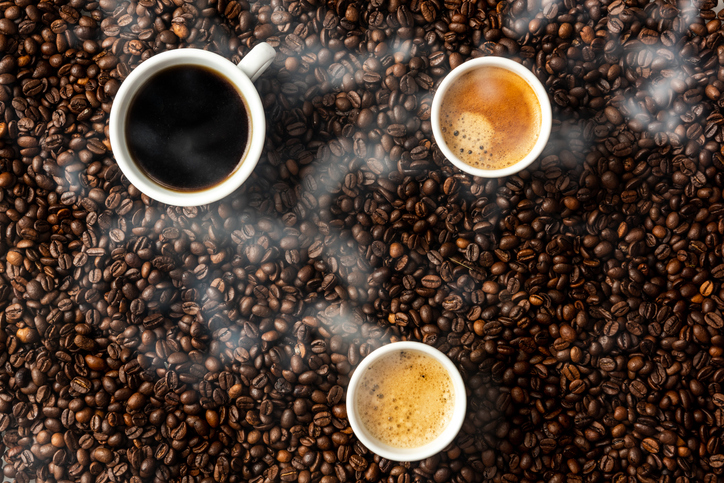 Hot roasted coffee background with steam, beans and cups