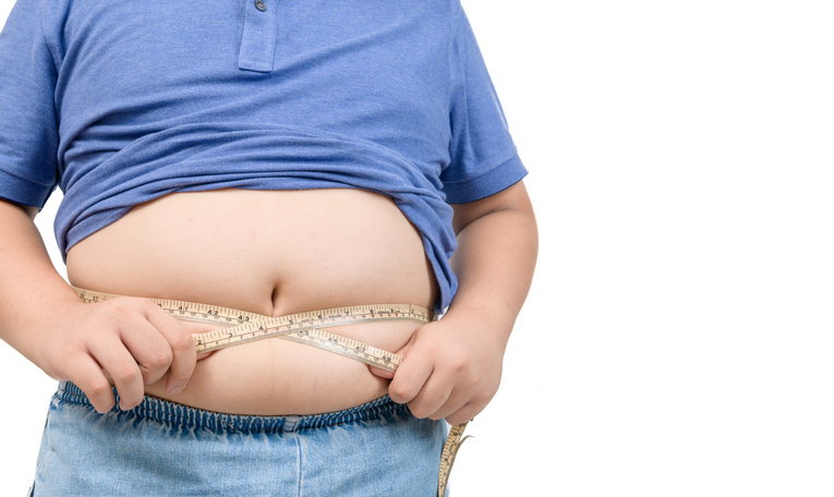 Obese boy measures his fat belly with a measuring tape isolated on white background, health care and diet food concept