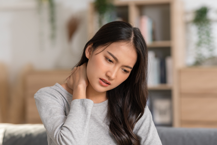 An Asian woman  do self massage at her neck and shoulders. She has got back and pain on her muscles. Massage could help her release her pain but the best way is to asking the advices from the doctor.