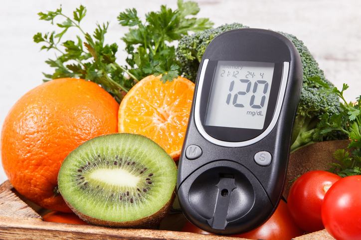 Glucometer with result of sugar level and natural fruits with vegetables. Diabetes and nutritious healthy food containing minerals and vitamins